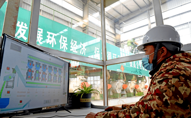 淮南市壽縣一家顆粒廠工人正在操控秸稈顆粒機械設備加工秸稈，生產生物燃料